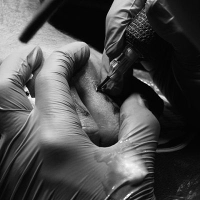 Close-up of a finger tattoo being done by a FIRME COPIAS artist in San Antonio